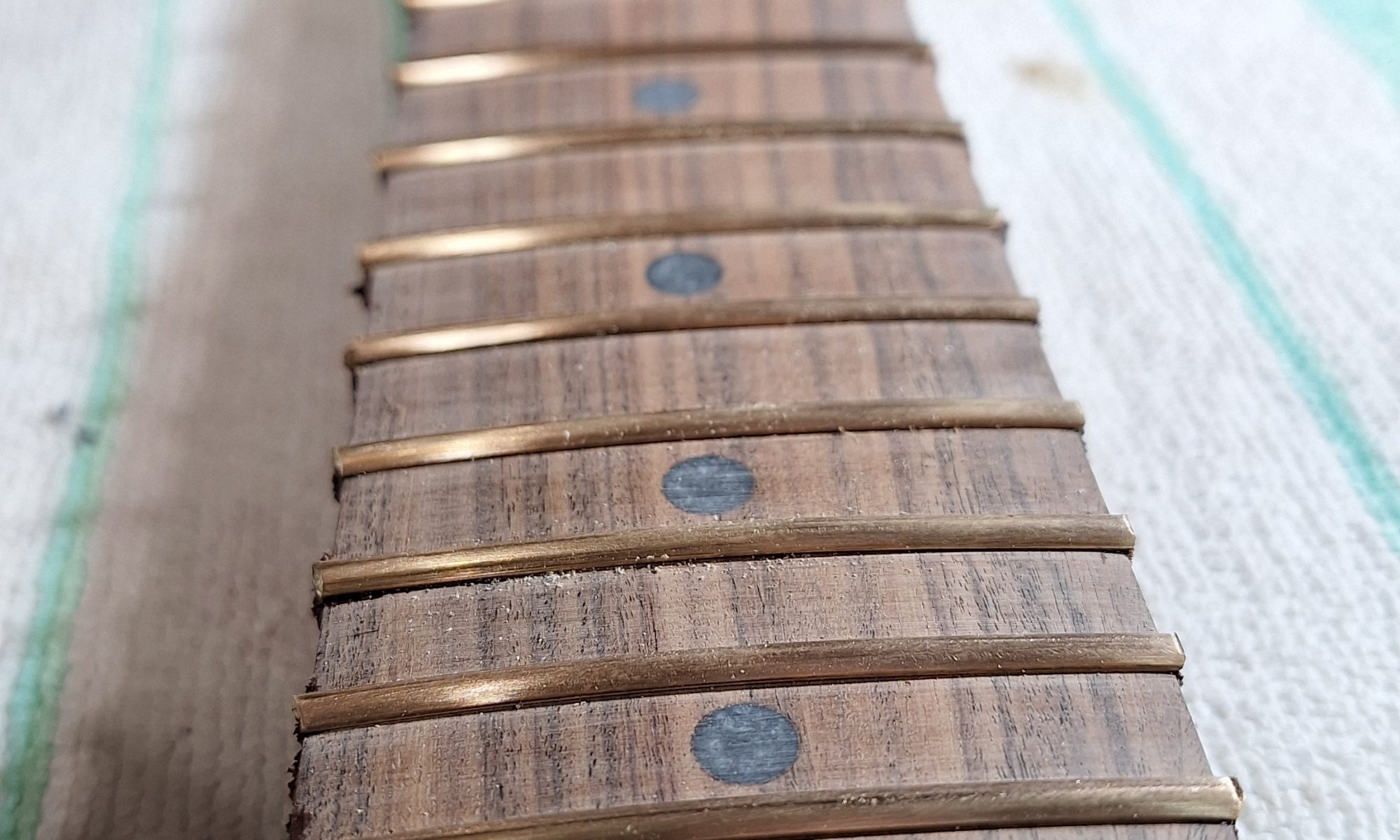 The artwork begins with beautiful wood. Patagonian Rosewood fretboard laid upon Central American Katalox body. Brass frets and dark pearl inlays.